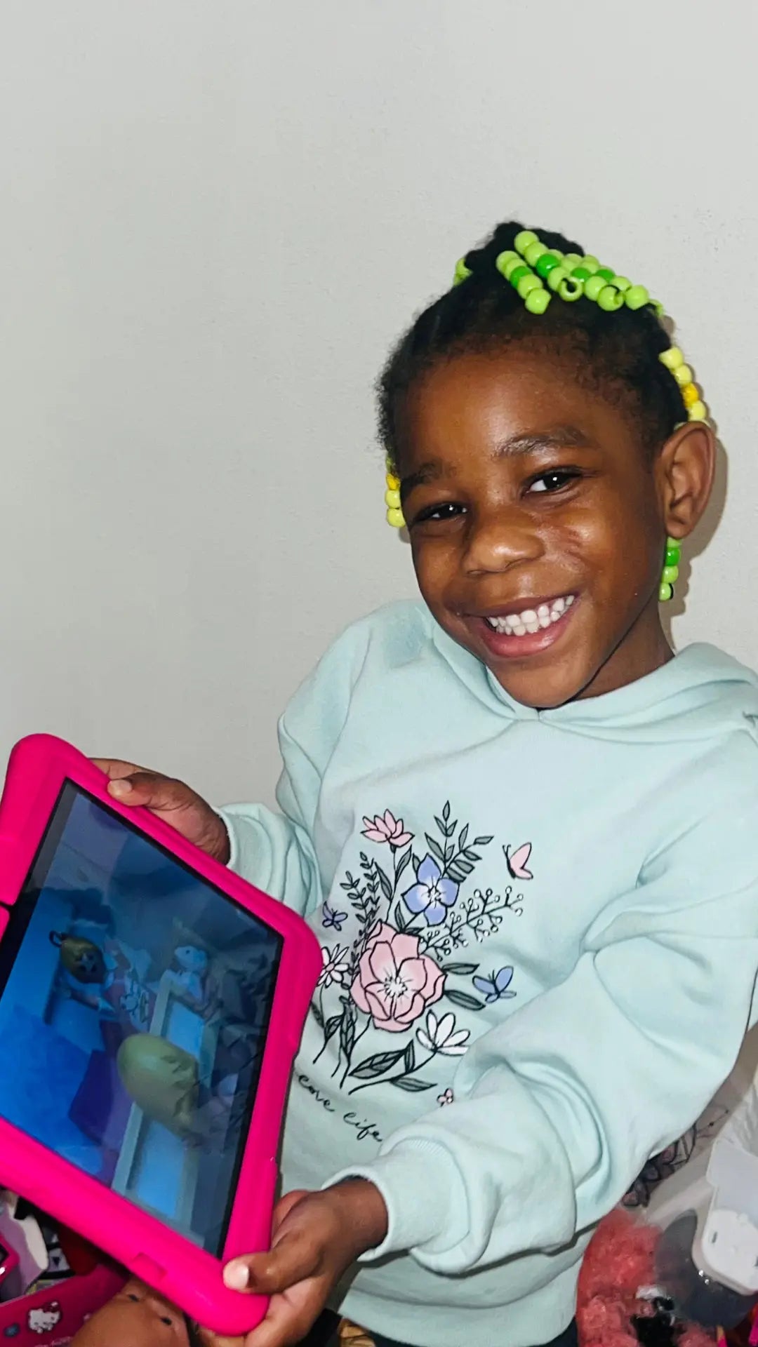 Kind toont een roze Kindertablet Pro aan de camera – educatief en kindvriendelijk