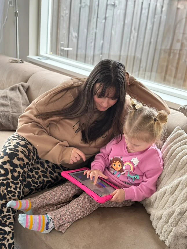 Moeder helpt haar kind met een leerzaam spel op een kindertablet